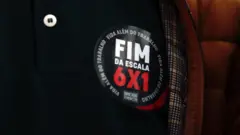 Foto de um adesivo escrito "fim da escala 6x1".
