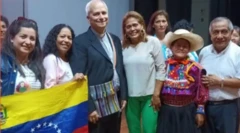 Lizbeth Díaz, junto al entonces obispo Robert Prevost y una bandera venezolana.
