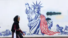 امرأة إيرانية تسير بجوار جدارية مناهضة للولايات المتحدة في طهران، إيران، في 23 فبراير شباط 2026.