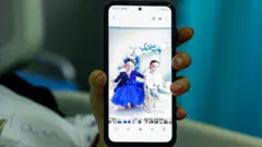 أماني بزي، امرأة أصيبت بجروح بالغة جراء غارة إسرائيلية بطائرة مسيرة في اليوم السابق في بنت جبيل جنوب لبنان، تعرض صور أطفالها القتلى عبر هاتفها أثناء استراحتها في مستشفى في تبنين في 22 سبتمبر/أيلول 2025. 