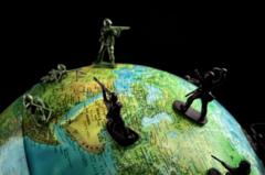 Globo terráqueo con soldados de plomo sobre él.