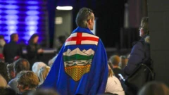 Defensor da emancipação de Alberta carrega uma bandeira da província nas costas, ao se levantar durante um evento no Conselho pela Independência de Alberta, em Calgary, Alberta (Canadá)