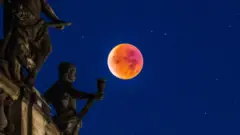 Hoton wani cikakken wata kenan da ya yi kusufi a 2015, yana wucewa ta saman wani gini