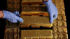 Two hands on gold bars