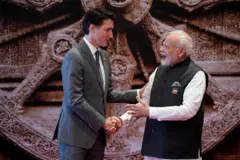 Indian PM Narendra Modi (right) shakes hand with Canada's Justin Trudeau standing next to each other. ඉන්දීය අග්‍රාමාත්‍ය නරේන්ද්‍ර මෝදි (දකුණ) කැනඩාවේ ජස්ටින් ටෘඩෝ එකිනෙකා අසල සිටගෙන අතට අත දෙමින්.
