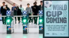 Catracas ao lado do letreiro com os dizeres 'A Copa do Mundo está chegando'