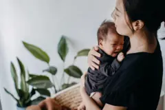 Mulher conforta um bebê que chora