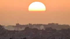 صورة تظهر غروب الشمس على شمالي قطاع غزة، ويبدو فيها دمار واسع النطاق.