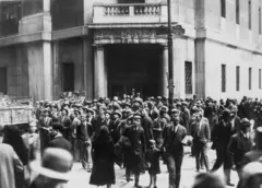 Muchas personas paradas frente a la bolsa de Nueva York, esperando noticias sobre su dinero.