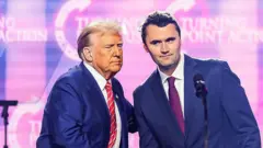 El activista de derecha estadounidense Charlie Kirk (der.) habla en el escenario con el presidente Donald Trump en el America Fest 2024 en Phoenix, Arizona, el 22 de diciembre de 2024.