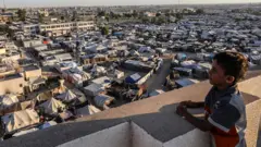 طفل فلسطيني ينظر إلى المخيمات في المواصي