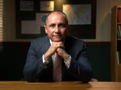 Imagem de Michael Viriato usando terno preto e olhando diretamente para a câmera