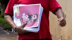 A supporter holds campaign leaflets of Anura Kumara Dissanayake, presidential candidate of National People’s Power(NPP) during the street election campaign. 