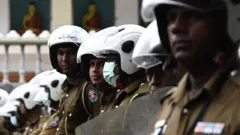 Police special task force personnel stand guard blocking a road as demonstrators (not pictured) take part in a protest march against Sri Lankan President Ranil Wickremesinghe towards the Presidential secretariat office in Colombo on July 22, 2022
