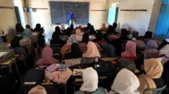 طالبات تدرسن في الفصل بعد استئناف الدراسة في المدرسة.