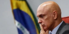 O ministro Alexandre de Moraes e ao fundo uma bandeira do Brasil