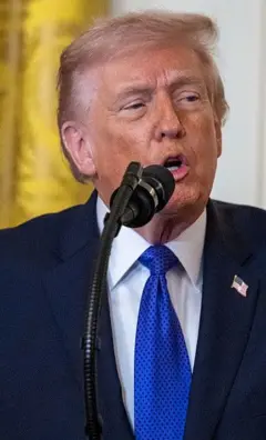 Trump falando em um microfone