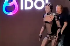 Robô andando. Atrás dele há uma pessoa