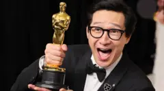 Ke Huy Quan memegang piala Oscar