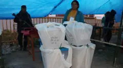 मतपेटिका बुझाउँदै मतदान केन्द्रका कर्मचारी 