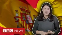 Repórter Julia Braun diante de imagem de bandeira da Espanha
