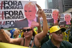 Seguidores de Bolsonaro con carteles que leen "Fuera Moraes", con la imagen del juez Alexandre de Moraes.