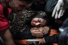 امرأة  داخل مستشفى شهداء الأقصى في دير البلح وسط قطاع غزة، تلقي النظرة الأخير على جثة طفلها