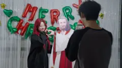 예수 등신대를 두고 손하트 사진을 찍고 있는 여성이 있다