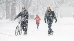 Tres personas caminan en la nieve en Nueva York