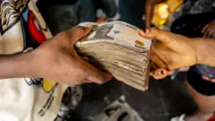 Ọwọ́ méjì tó kó owó dání