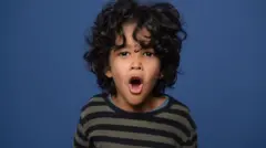 Young boy shouting with blue background
