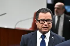 Garnier em pé em sala do STF conversando com alguém