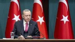 Erdoğan oturuyor gülüyor