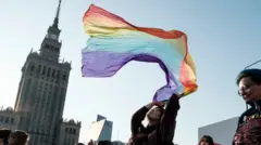 Kobieta powiewa tęczową flagą, w tle Pałac Kultury