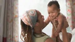ከእናቱ ጋር የሚጫወት ጨቅላ ሕጻን