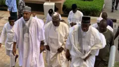 Men in white Agbada Dey climb di steps of di federal high court, Abuja