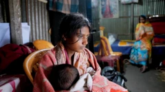 தீபு தாஸின் மனைவி மேக்னா ராணி, ஒன்றரை வயதுடைய மகளுடன். பின்னணியில் தீபு தாஸின் தாய் காணப்படுகிறார் 