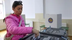 Тамнокоса девојка у розе зимској јакни са смеђом торбом преко рамена гласа на изборима на Косову