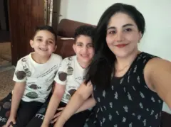 Randa Dowiar em primeiro plano em um selfie com seus dois filhos pequenos