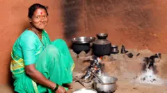 चुलीजवळ बसलेली महिला 