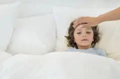 A young chid with fever in bed