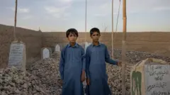 Bilal ve İmran Uzbakzai annelerinin mezarı başında. 