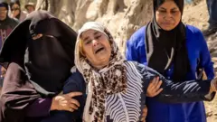 Para korban selamat di Desa Tafeghaghte tak kuasa menahan sedih saat menguburkan orang-orang yang dicintainya.