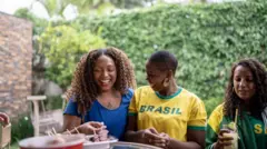 Três mulheres comendo churrasco