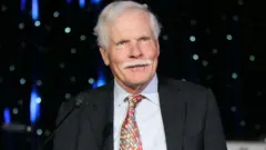 Ted Turner wear black suit and white shirt