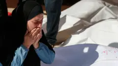 سيدة تبكي خلال تشييع جنازة الفلسطينيين ممن قُتلوا في الغارات الإسرائيلية، في المستشفى الإندونيسي في بيت لاهيا، في شمال قطاع غزة، 16 مايو 2025
