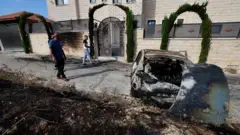Палестинские жители оценивают ущерб после нападения израильских поселенцев на деревню Джит