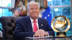Donald Trump sitting and smiling
