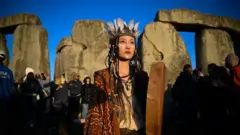 Daisy, seorang praktisi dukun China menyaksikan matahari terbit di Stonehenge, pada 21 Juni 2024 di Wiltshire, Inggris.