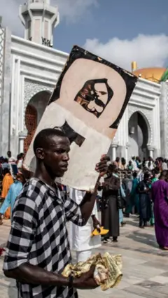 Fidèle qui porte sur son épaule une photo de Cheikh Ahmadou Bamba